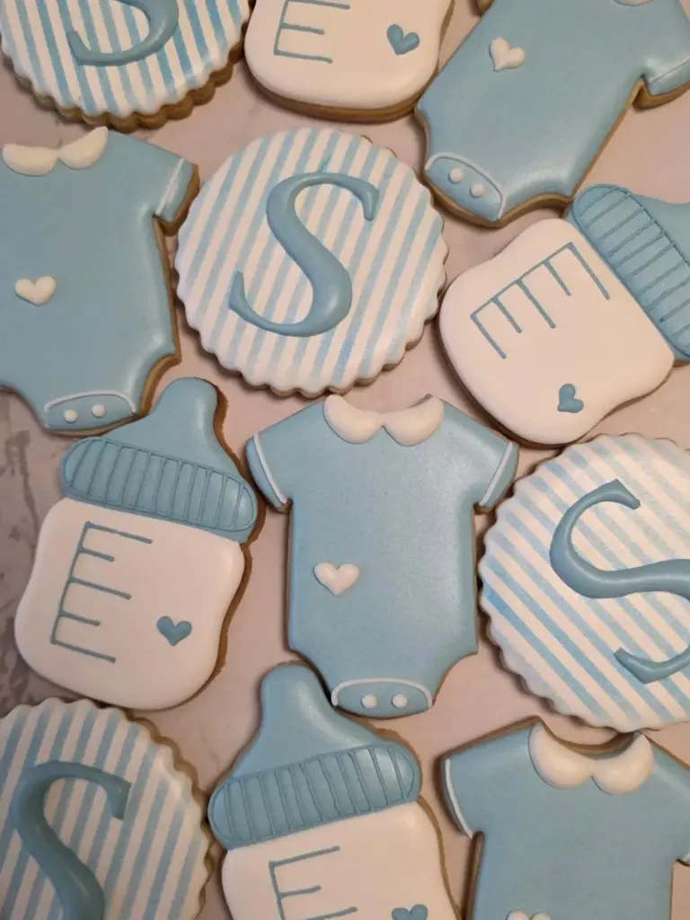 Galletas para baby shower celeste con bodies, mamaderas e inicial personalizada