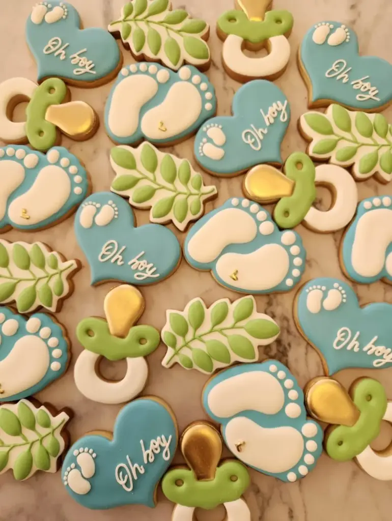 Galletas de baby shower oh boy con piecitos, chupetes y hojas en celeste y verde