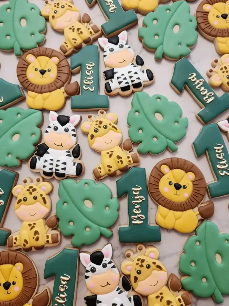 Galletas de animales safari para primer cumpleaños con hojas tropicales y número 1